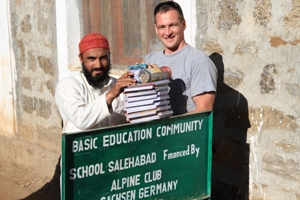 Markus übergibt die Schulbücher an den Lehrer in Salehabad